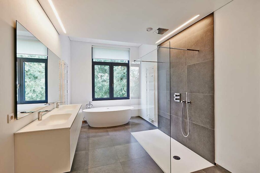 Modern bathroom with accessible, curbless shower and freestanding tub